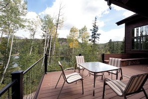 A deck with a table and chairs, overlooking a forested valley. - Amazing Mtn Home on Columbine Lake - 1 mile to Purg - AC/Shuffleboard/Views (Durango)
