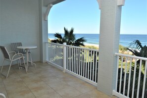 A balcony with a view of the ocean, white railings, and a small table with chairs. - "Heron's Perch" Direct Ocean Front, Unit 743 at Cinnamon Beach (Palm Coast)