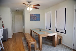 A dining area with a wooden table, benches, and a ceiling fan. - A "Bay" Cation - Nice home,LINENS AND TOWELS PROVIDED  Quiet area-  OB2 (Chincoteague)