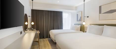 A hotel room with a large bed, a desk with a flat-screen TV, a chair, and a large window with curtains.