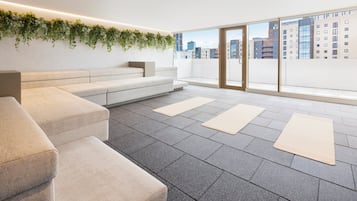 Et moderne loungeområde med en sofa, et lille bord og en plante på væggen.