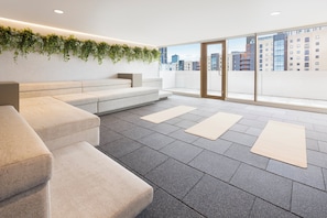 A modern lounge area with a sofa, a small table, and a wall-mounted plant. - Leonardo Hotel Manchester Piccadilly (Manchester)