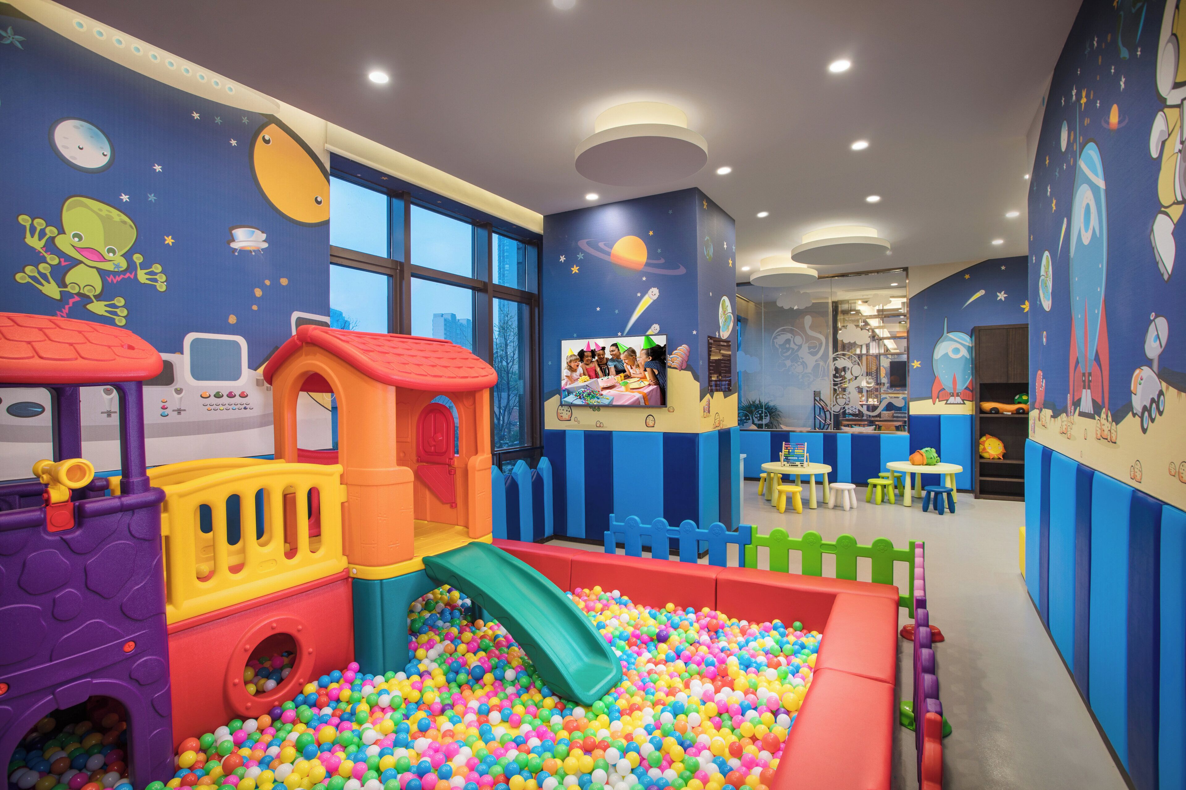Zona de juegos para niños con piscina de pelotas, toboganes y estructuras coloridas.
