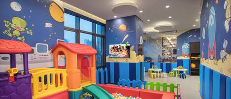 Zona de juegos para niños con piscina de pelotas, toboganes y estructuras coloridas.