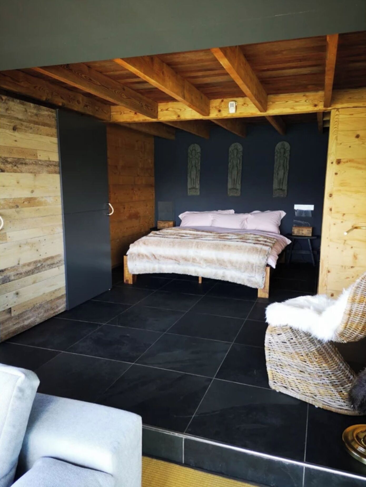 A bedroom with a bed, a chair, and a small table.