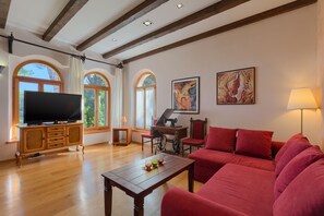 Relax in this inviting living room with a flat-screen TV, comfortable sofa, and armchair.