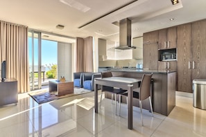 Relax in this stylish living space with a dining area, sofa, and kitchenette.