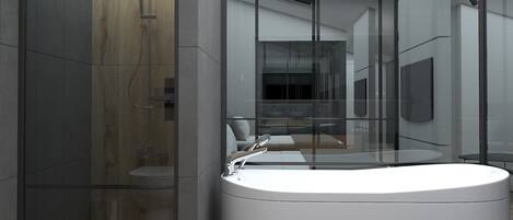 A modern bathroom with a freestanding bathtub, a glass-enclosed shower area, and a visible kitchen area in the background.