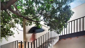 Una escalera con estructura de hormigón, barandillas de metal y suelo de grava.