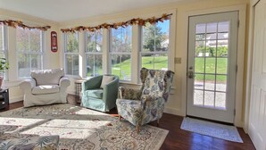A sunlit room with a large window, a door, and three chairs. - Historic Colonial...Close to Village Green (Litchfield)