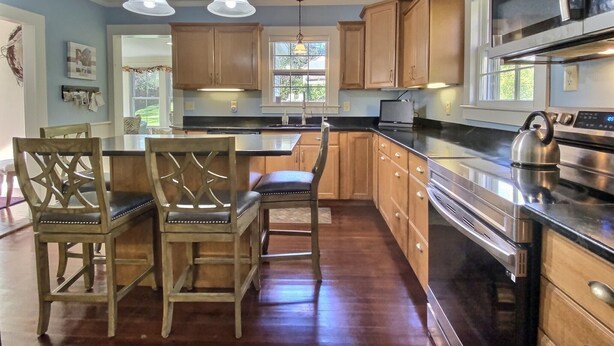 A modern kitchen with wooden cabinets, a stainless steel refrigerator, and a kettle on the counter. - Historic Colonial...Close to Village Green (Litchfield)
