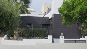 A modern building with a dark facade, a visible entrance, and a number '620' sign. - Golf & Sea Top location (Villamartin)