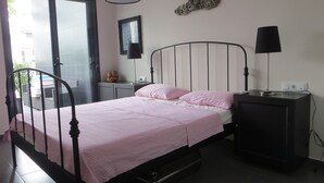 A bedroom with a bed, bedside tables, a lamp, a mirror, and a decorative wall piece. - Golf & Sea Top location (Villamartin)
