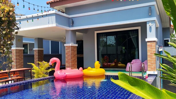 Una piscina amb joguines inflables, un porxo cobert i llums penjants.