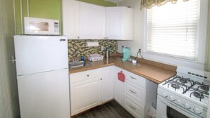 A kitchen with white cabinets, a microwave, a stove, and a window with blinds. - 1st Floor Studio 2 Blocks to Beach & Main Ave | Quiet & Bright | Near Asbury (Neptune Township)