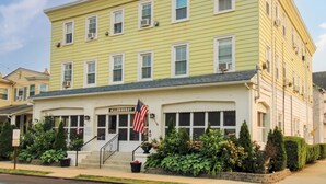 A yellow building with a sign reading "ALLENHURST" and an American flag. - 1st Floor Studio 2 Blocks to Beach & Main Ave | Quiet & Bright | Near Asbury (Neptune Township)