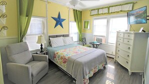 A bedroom with a bed, a chair, a dresser, a ceiling fan, and a TV. - 1st Floor Studio 2 Blocks to Beach & Main Ave | Quiet & Bright | Near Asbury (Neptune Township)