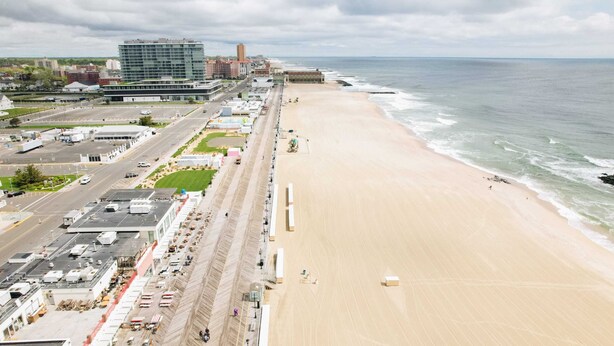 A coastal cityscape with a wide beach, a road parallel to the shore, and buildings including a large hotel. - 1st Floor Studio 2 Blocks to Beach & Main Ave | Quiet & Bright | Near Asbury (Neptune Township)