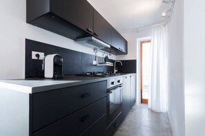Una cuina moderna amb forn integrat, cafetera i campana extractora.