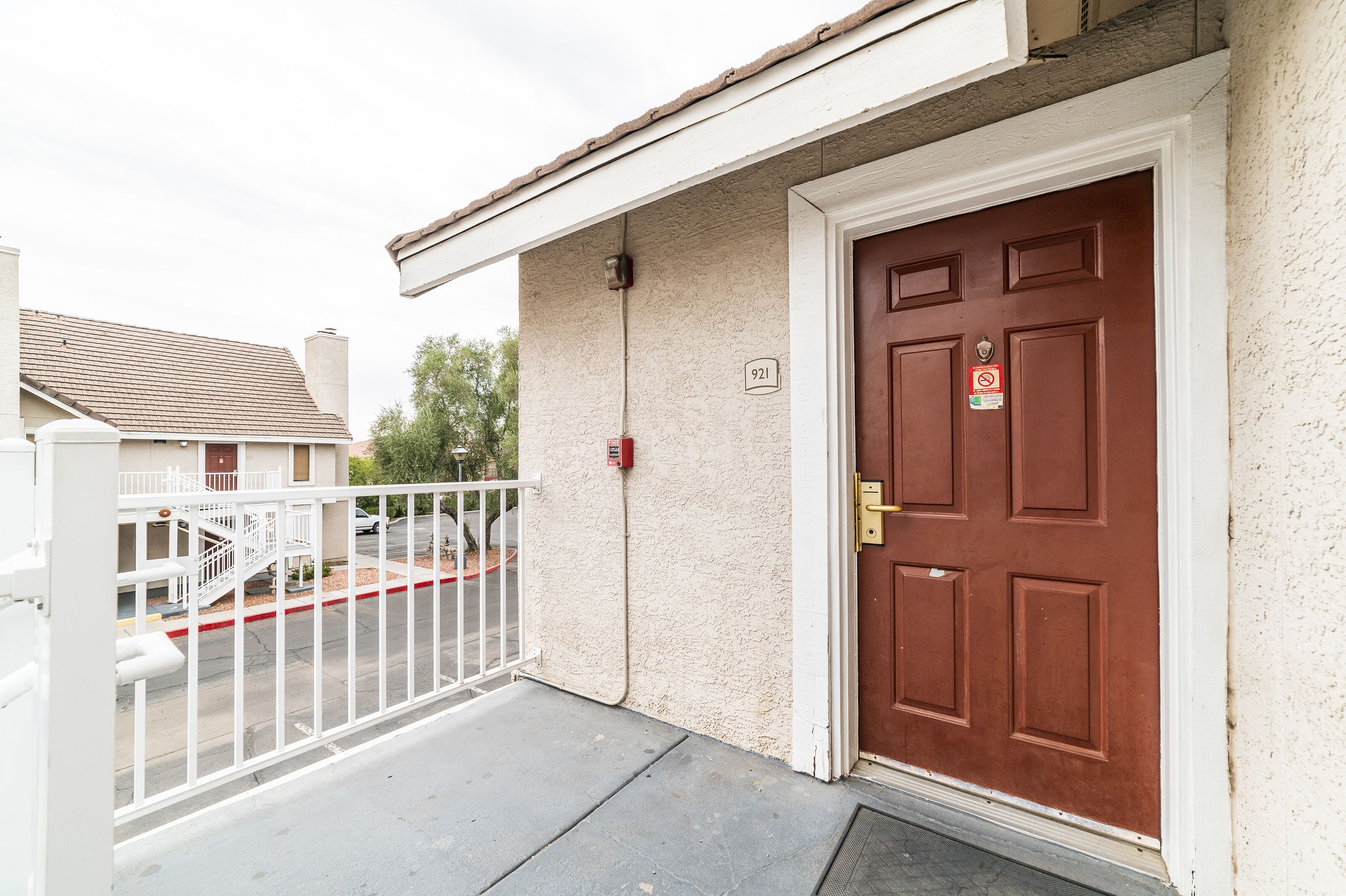 A residential building with a red door, a white mailbox, and a number '921' on the wall.