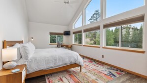 A bedroom with a bed, a desk, a chair, a TV, and large windows. - Luxury Home-Walk to everything in Frisco. Hot tub, ski, fireplace 3BD, 3.5BA



 (Frisco)