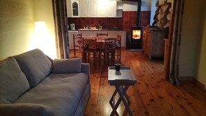Una sala de estar acogedora con un sofá, una mesita y una chimenea al fondo.