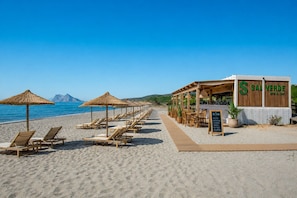 A beachside restaurant with outdoor seating, a wooden deck, and a signboard listing menu items. - The Links II Sea View 2473 La Alcaidesa Golf (La Alcaidesa)