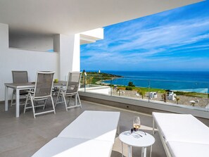 A balcony with a table and chairs, a small round table with a glass of wine, and a view of the ocean. - The Links II Sea View 2473 La Alcaidesa Golf (La Alcaidesa)