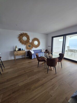 A modern living room with a dining area, a sofa, a coffee table, and a view through a large glass door. - The Links II Sea View 2473 La Alcaidesa Golf (La Alcaidesa)