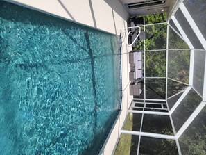 Relax by the clear pool surrounded by a geometric enclosure and lounge chairs.