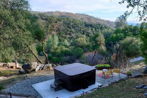 A hot tub in a natural setting with a view of a forested hillside. - Hot Tub, Views, Privacy, Game Room, just 5 min from Downtown! (Oakhurst)