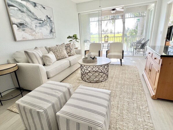 A living room with a sofa, two ottomans, a coffee table, and a cabinet. -  PLAYERS CLUB AVAILABLE, Professionally Renovated, 3 Bedroom Golf Condo (Naples)