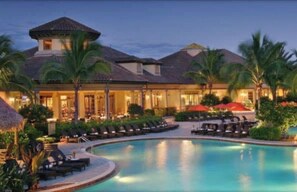 A resort with a pool, lounge chairs, and palm trees. -  PLAYERS CLUB AVAILABLE, Professionally Renovated, 3 Bedroom Golf Condo (Naples)