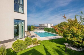 A modern building with a swimming pool, a small garden area, and a view of the surrounding landscape. - Holiday apartment mit privatem Pool und Meerblick (Zidarići)
