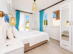 Un dormitorio con cama, mesitas de noche, un armario y una ventana con cortinas.