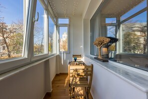 A narrow hallway with large windows, wooden flooring, and a table with chairs. - Cosy & Quiet Luxury Apartment - Unirii Square - Old Town - Adela Accommodation (București)