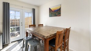 A dining area with a large table, four chairs, a bench, and a sliding glass door leading to an outdoor patio. - Spacious Williams Retreat near Grand Canyon (Williams)