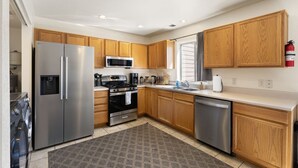 A modern kitchen with stainless steel appliances, wooden cabinets, and a tiled backsplash. - Spacious Williams Retreat near Grand Canyon (Williams)