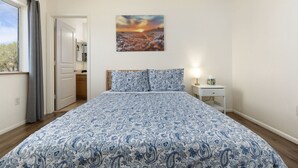 A bedroom with a bed, a nightstand, a painting, and a window with curtains. - Spacious Williams Retreat near Grand Canyon (Williams)