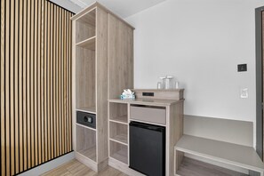 A modern room with a built-in wardrobe, a small kitchenette, and a bench. - Tropical Palms Hotel (Clearwater)
