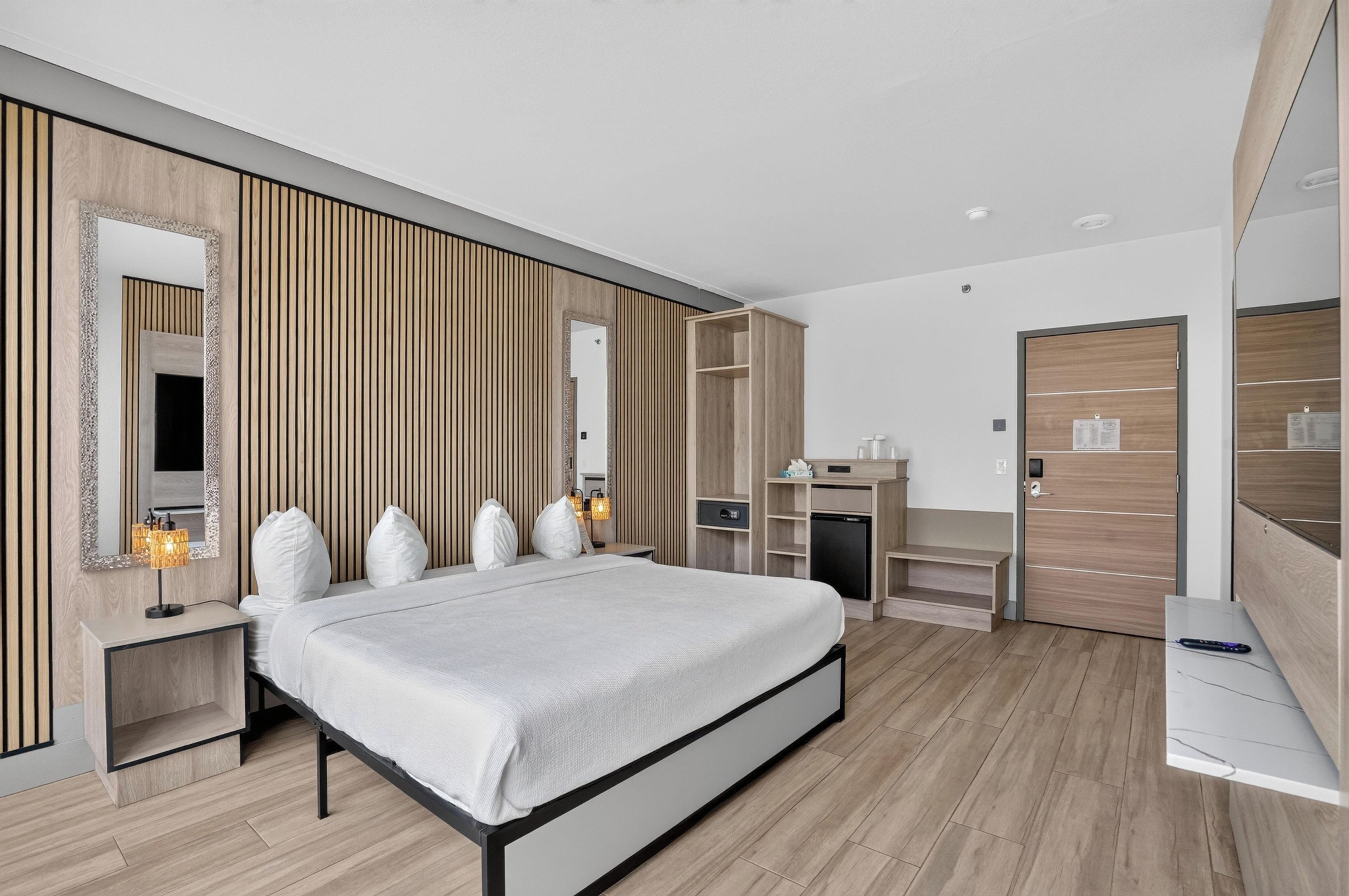 A modern bedroom with a bed, bedside tables, a wardrobe, and a desk.