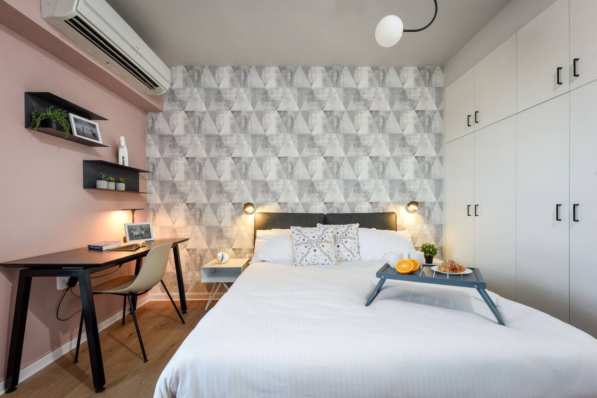 Un dormitorio con cama, mesita de noche, lámpara y armario.