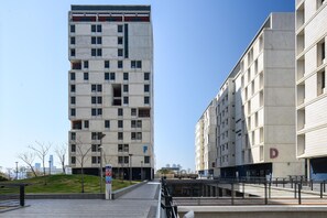 A modern multi-story building with a flat facade, several balconies, and a clear sky. - TLV TAU By Seanrent (Tel Aviv)