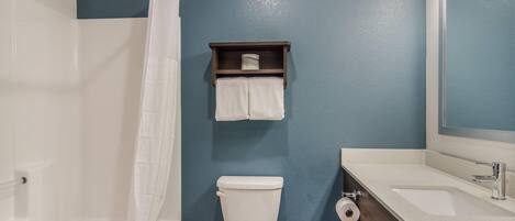 A bathroom with a bathtub, toilet, and sink.