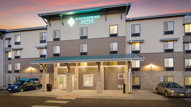 Monikerroksinen hotelli, jonka kyltissä lukee: ”Woodspring Suites”.