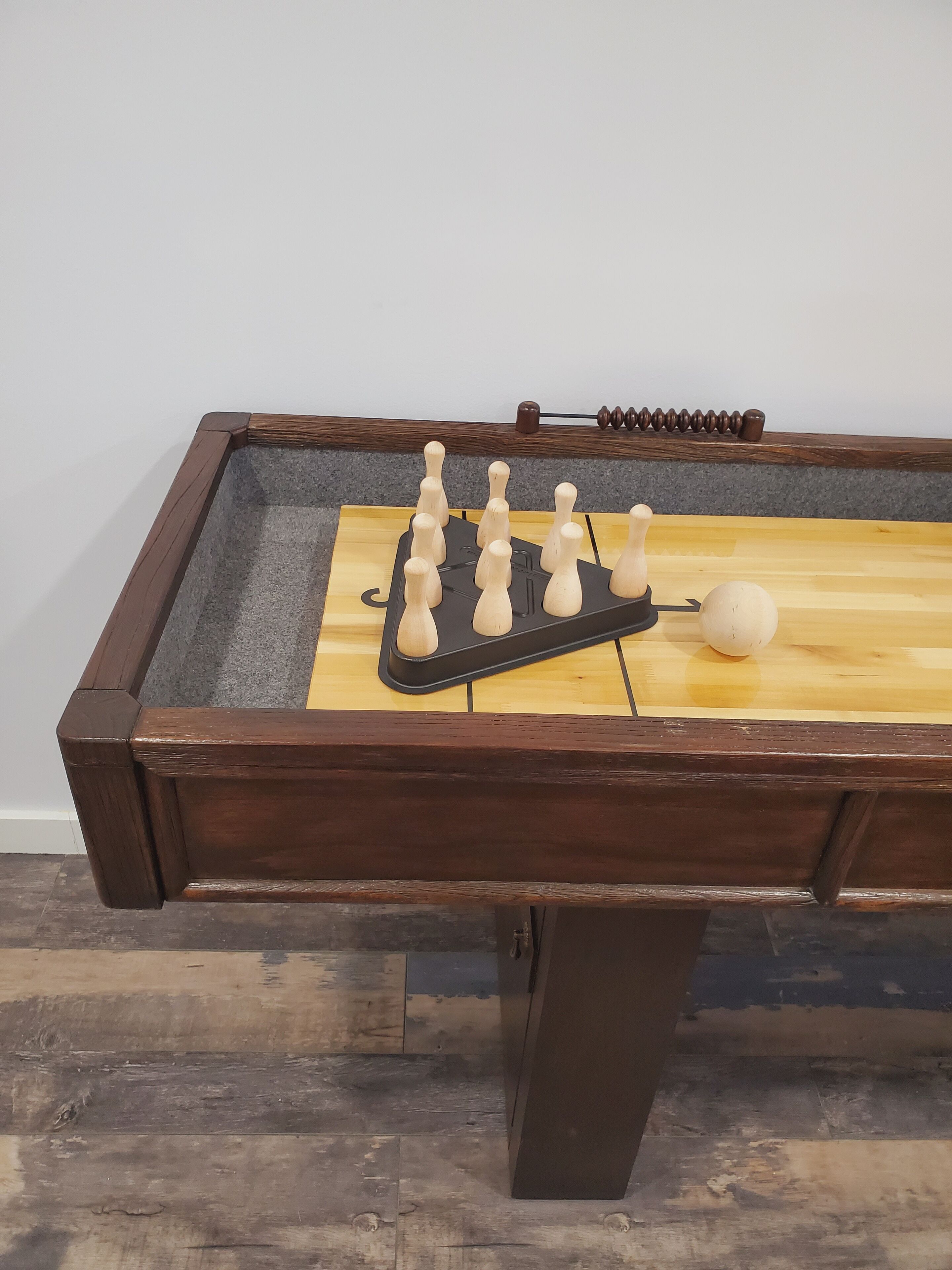 A foosball table with a wooden frame and a light-colored playing surface.