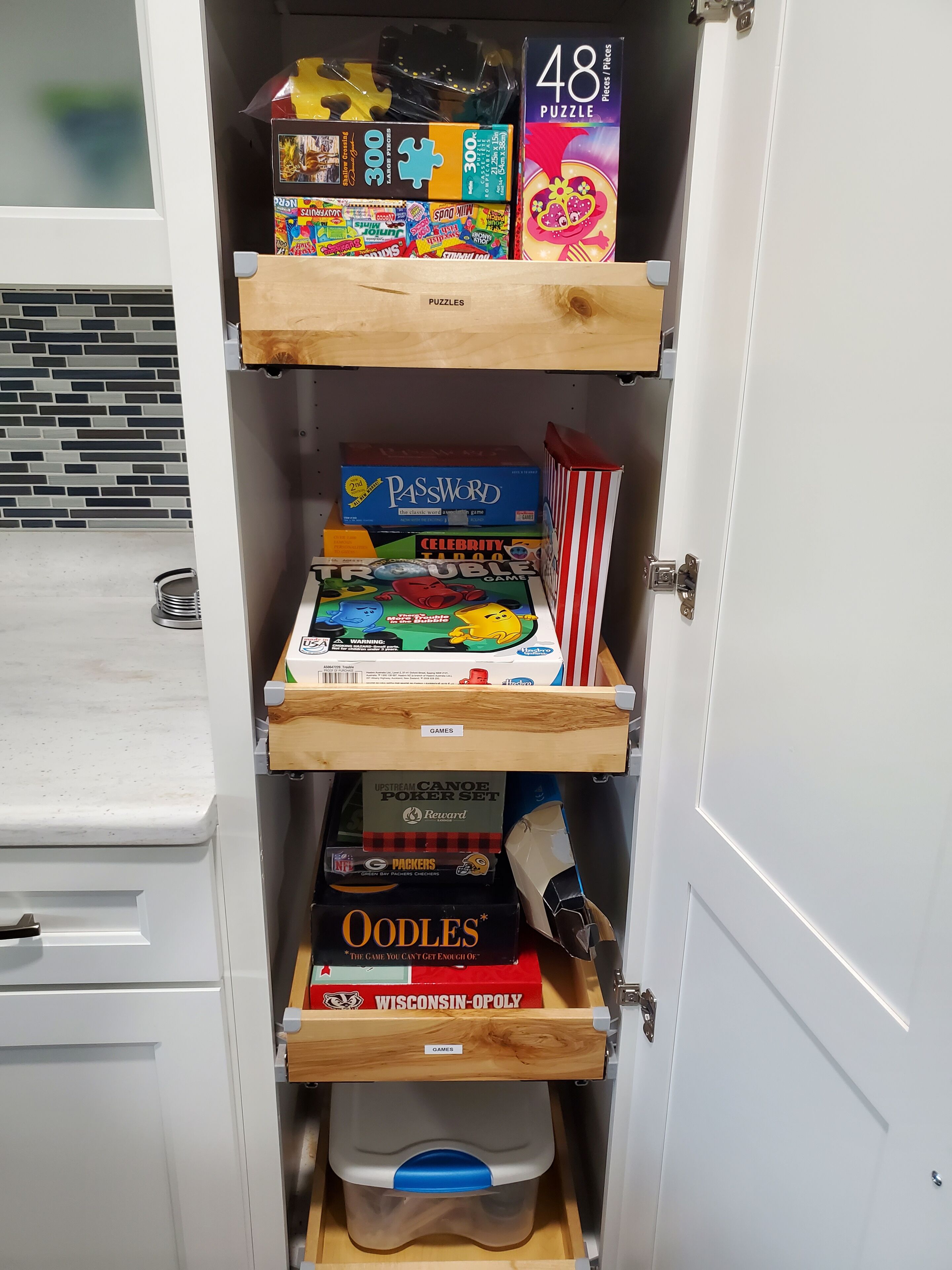 Ein Schrank mit Regalen, gefüllt mit verschiedenen Gesellschaftsspielen und Puzzles.