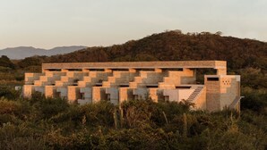 A modern building with a unique geometric design, surrounded by natural vegetation and hills in the background. - Terrestre, a Member of Design Hotels (Villa de Tututepec de Melchor Ocampo)