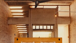 A bedroom with a large bed, wooden headboard, two bedside tables, and a ceiling fan. - Terrestre, a Member of Design Hotels (Villa de Tututepec de Melchor Ocampo)