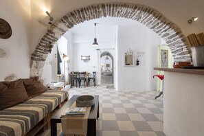 Experience the warm ambiance of this inviting space with a high ceiling, arched structure, and cozy seating area.